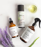 Set of hair care products including serum, dry shampoo, and tonic on a white background with lavender.