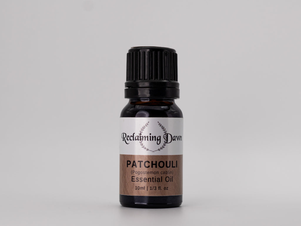 Bottle of Reclaiming Dawn Patchouli essential oil on a gray background