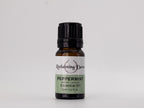 Bottle of peppermint essential oil with a label on a light gray background
