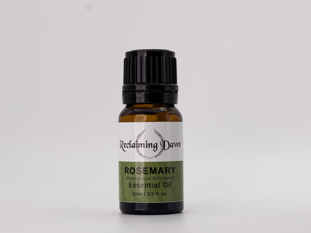 Bottle of Reclamimg Dawn Rosemary essential oil on a light gray background